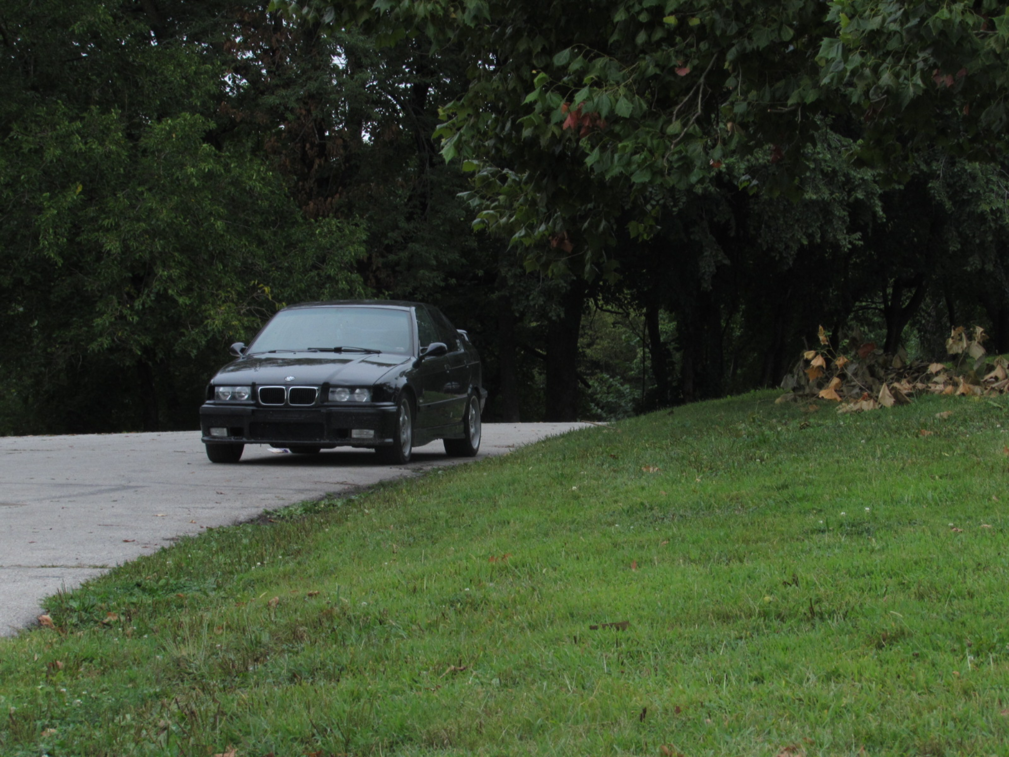Black BMW E36 on a quiet road